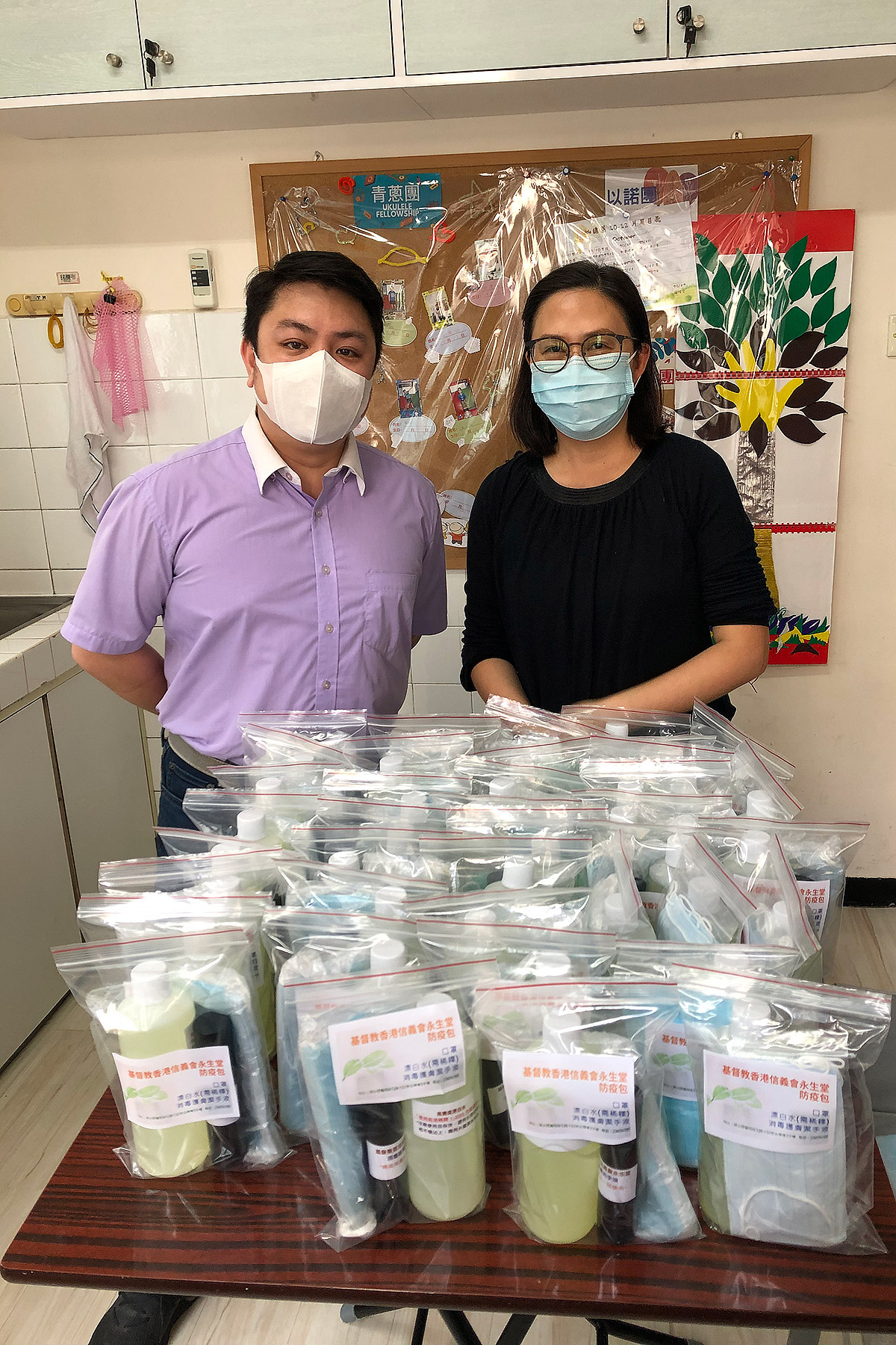 Rev. Ken Leung, pastor of the Eternal Life Lutheran Church, and a volunteer with supplies of hand sanitizer, masks and other hygiene products ready for distribution