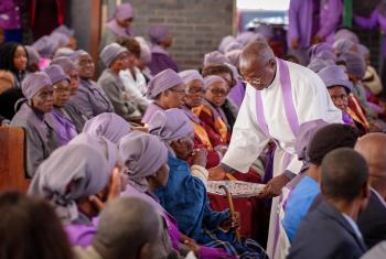 Before the COVID-19 pandemic, the LWF General Secretary paid a solidarity visit to Zimbabwe. In this photo, a pastor distributes Holy Communion during worship at the Njube Center parish of the Evangelical Lutheran Church in Zimbabwe. Photo: LWF/A. Danielsson