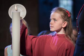 A girl lights a candle at Lund Cathedral, signifying one of the five ecumenical imperatives. Photo: LWF/Albin Hillert