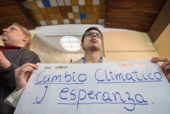 "Cambio Climático y Esperanza" (‘Climate Change and Hope') reads the text, as Lutheran World Federation delegate Sebastian Ignacio Muñoz Oyarzo from the Evangelical Lutheran Church in Chile holds a sheet of paper on which key discussion points have been summarized at an interfaith dialogue in Madrid, 1 December. All photos: LWF/Albin Hillert