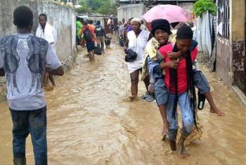 A survivor is carried to safety through a flooded street. Photos: LWF Haiti 