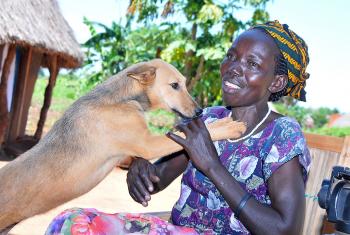 Molly Aringo with her dog. LWF has helped her embrace life again following a diagnosis of HIV. Photo: LWF/P. Kikomeko