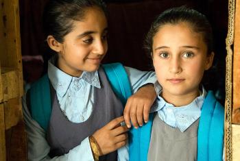 Caption: Shemaa (8) and Bushra (9) getting ready for school. The girls and their family live in a communal shelter with 31 other people. Photo: LWF/ Seivan Salim