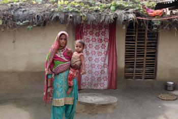 Sakina Khatun holds her youngest child in front of the family home, which needs a better roof and sanitation. All photos: LWF/ Y. Gautam