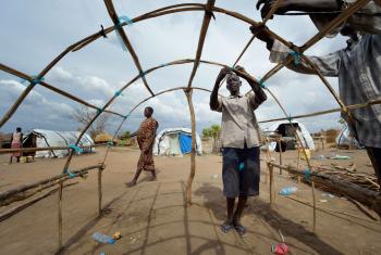 Men in South Sudan reconstruct their house after the village was destroyed in Jonglei. Photo: ACT/ Paul Jeffrey