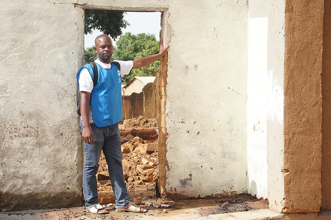 Armand Yabinti, community outreach officer for the LWF emergency program in CAR, outside the ruins of his house in Bohong village, Ouham PendÃ© prefecture.  Photo: LWF/P. Mumia