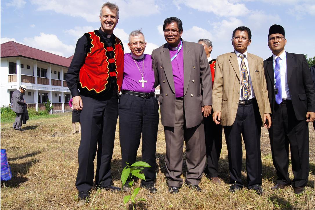 (From left) LWF General Secretary Martin Junge, LWF President Bishop Dr Munib Younan, LWF National Committee in Indonesia Chairperson Bishop Langsung Sitorus and other member church representatives with a Luther Garden partner tree planted at the Ecumenical Center of the Council of Protestant Indonesian Churches in North Sumatra on 15 June 2014. Photo: LWF/C. KÃ¤stner