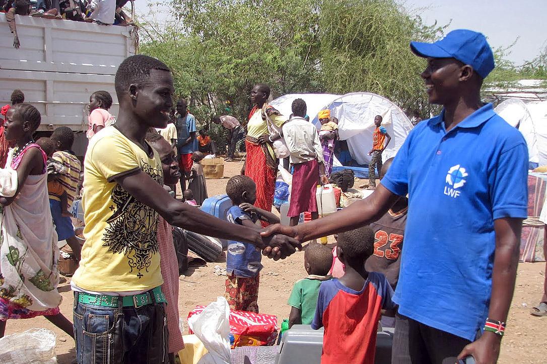 LWF staff member John Ekamais, right, with one of the new arrivals at the Kakuma reception center. Photo: LWF/James Macharia