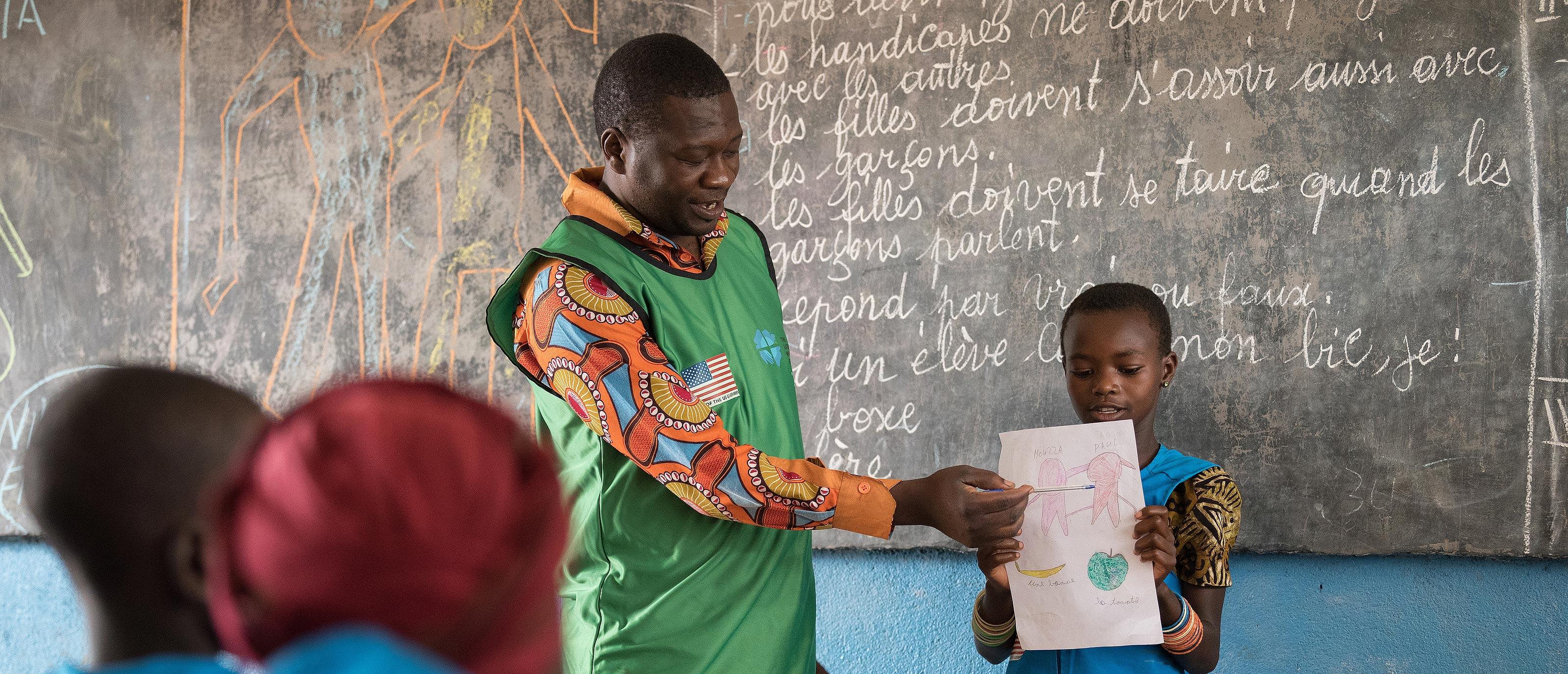 Painter and consulting artist Dogari Samson teaches children how to make drawings as a way to share messages of peace. All photos: LWF/Albin Hillert