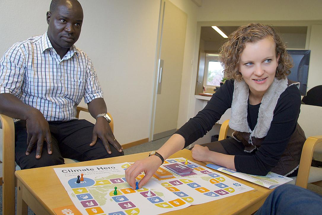 LWF program officer Lokiru Matendo Yohana (left) and youth secretary Caroline Richter come up with creative ideas for ending climate change as they play the LWF board game, Climate Hero. Photo: LWF/S. Cox