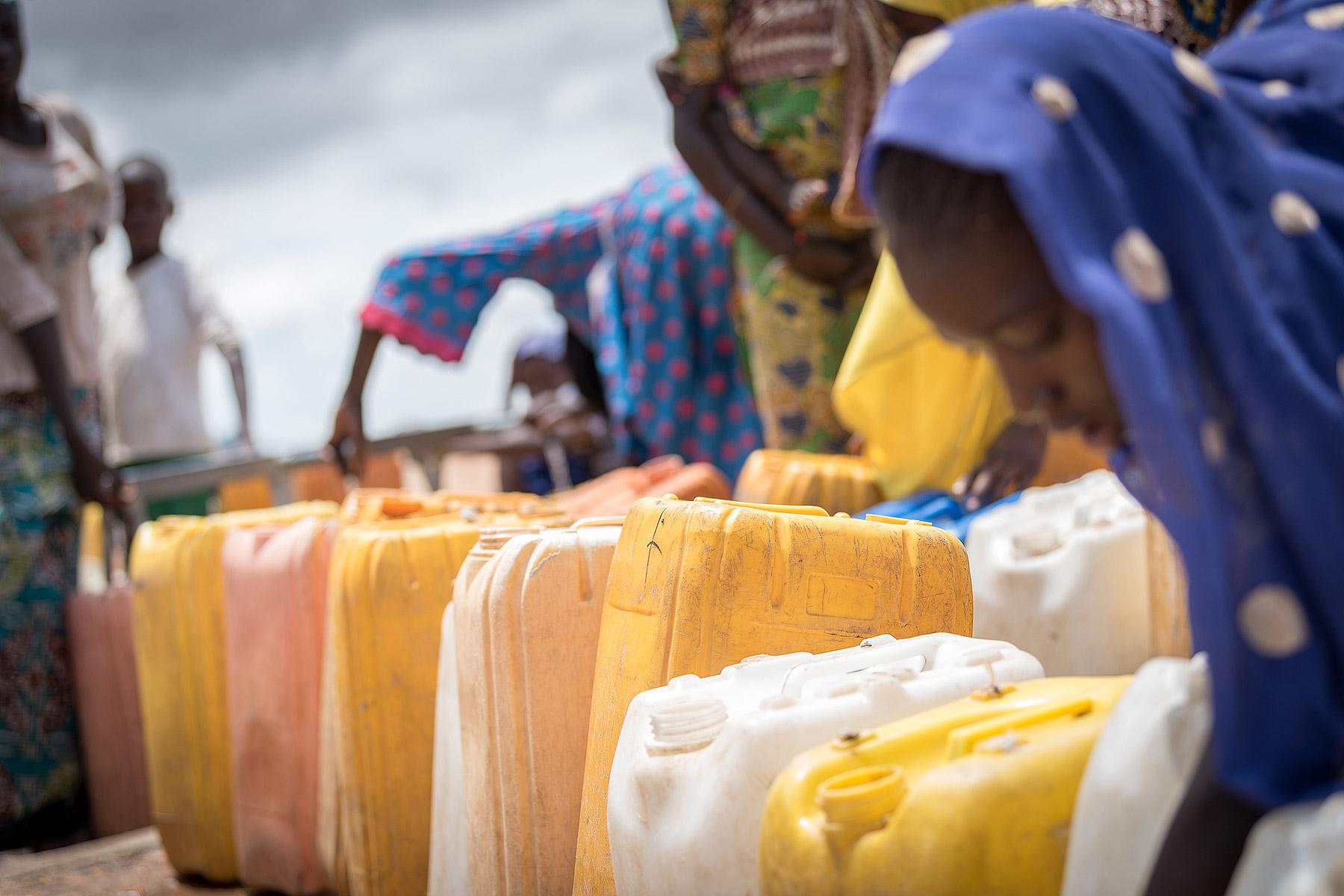 Im Flüchtlingslager in Minawao in der Region Hoher Norden in Kamerun stehen Frauen an, um ihre Kanister mit sauberem Trinkwasser aufzufüllen. In dem Flüchtlingslager leben rund 58.000 Flüchtlinge aus dem Nordosten Nigerias, die Hilfe und Unterstützung vom Lutherischen Weltbund und seinen Partnern erhalten. Fotos: LWB/Albin Hillert