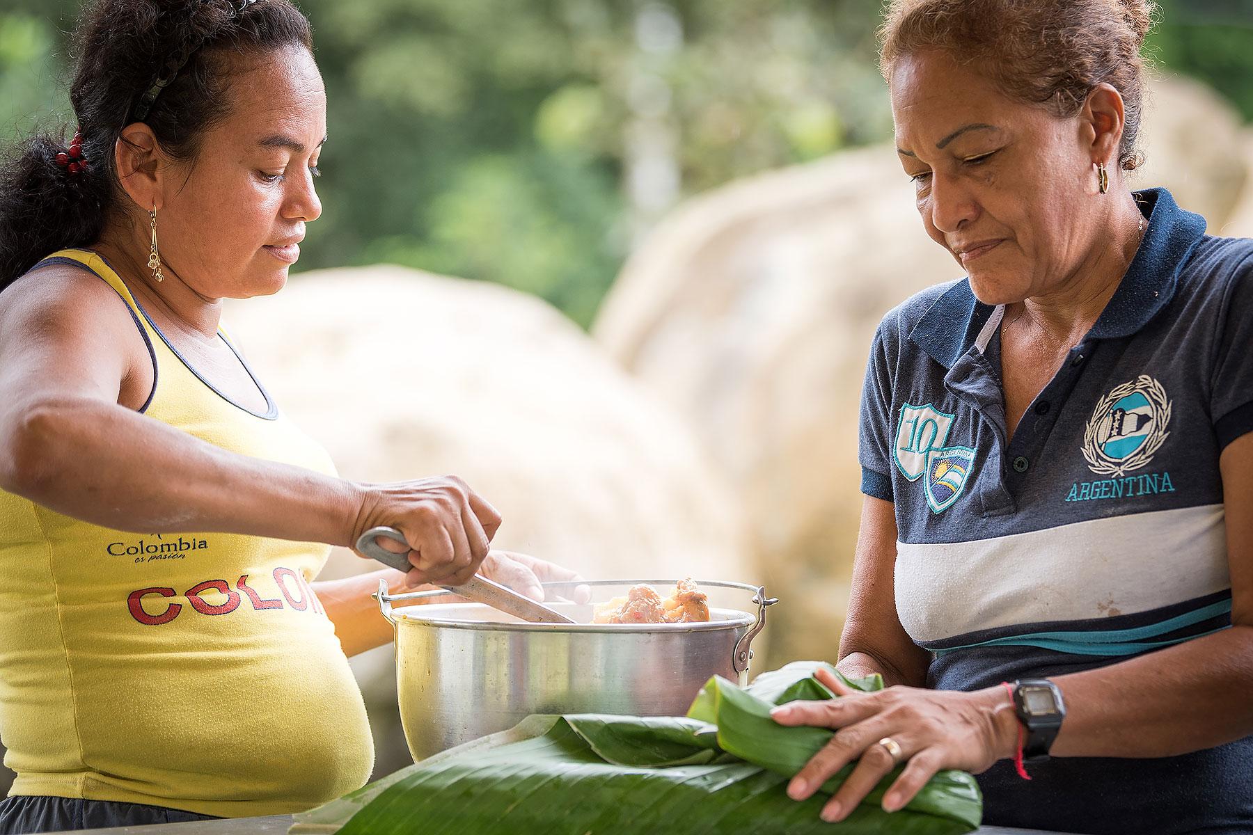 Mayerlis serves woman leader Aida a meal of sarapa â rice and chicken wrapped in a Cachibou leaf. Photo: LWF/Albin Hillert