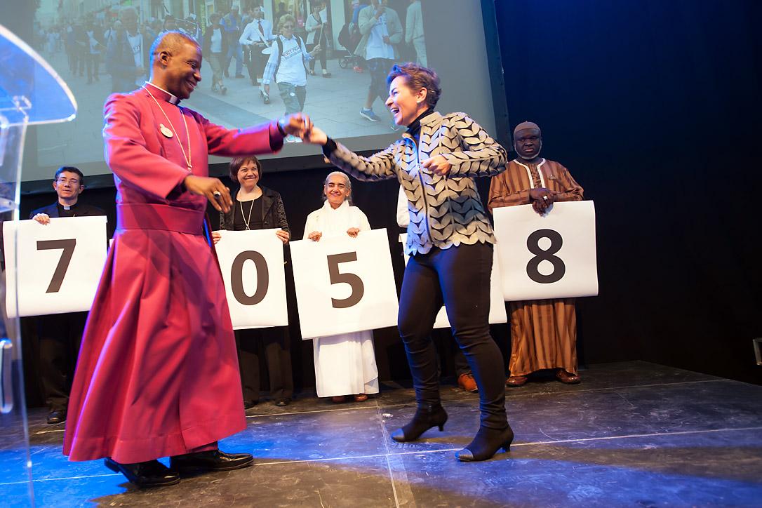 Christiana Figueres, Executive Secretary of the United Nations Framework Convention on Climate Change, dances with Archbishop Thabo Makgoba of South Africa to celebrate some 1.8 million signatures on an interfaith petition for climate justice during the COP21 climate summit in Paris, France. Photo: LWF/R. Rodrick Beiler