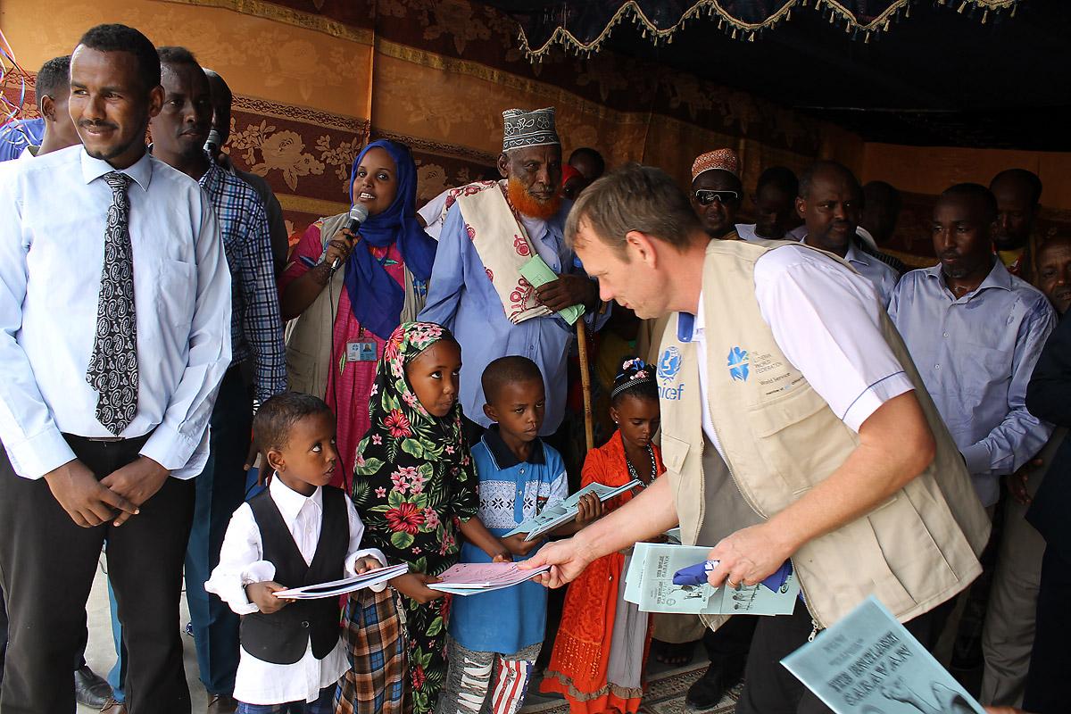 Der LWB-Ländervertreter Lennart Hernender überreicht Erstklässlern die nach dem neuen Lehrplan gestalteten Schulbücher. Foto: LWB Kenia-Dschibuti