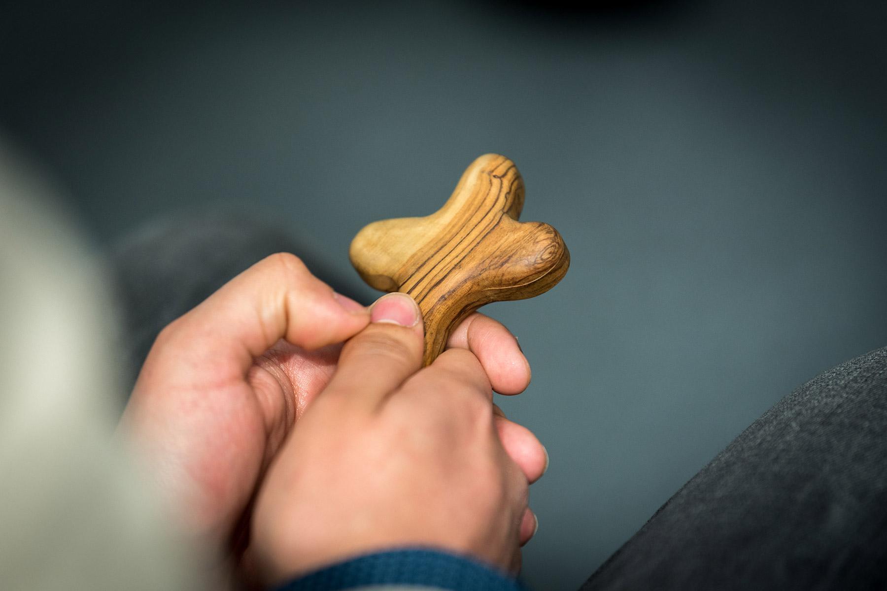 A young man holds a cross during morning prayer with the Lutheran World Federation delegates on day one of COP25 in Madrid. Photo: LWF/Albin Hillert
