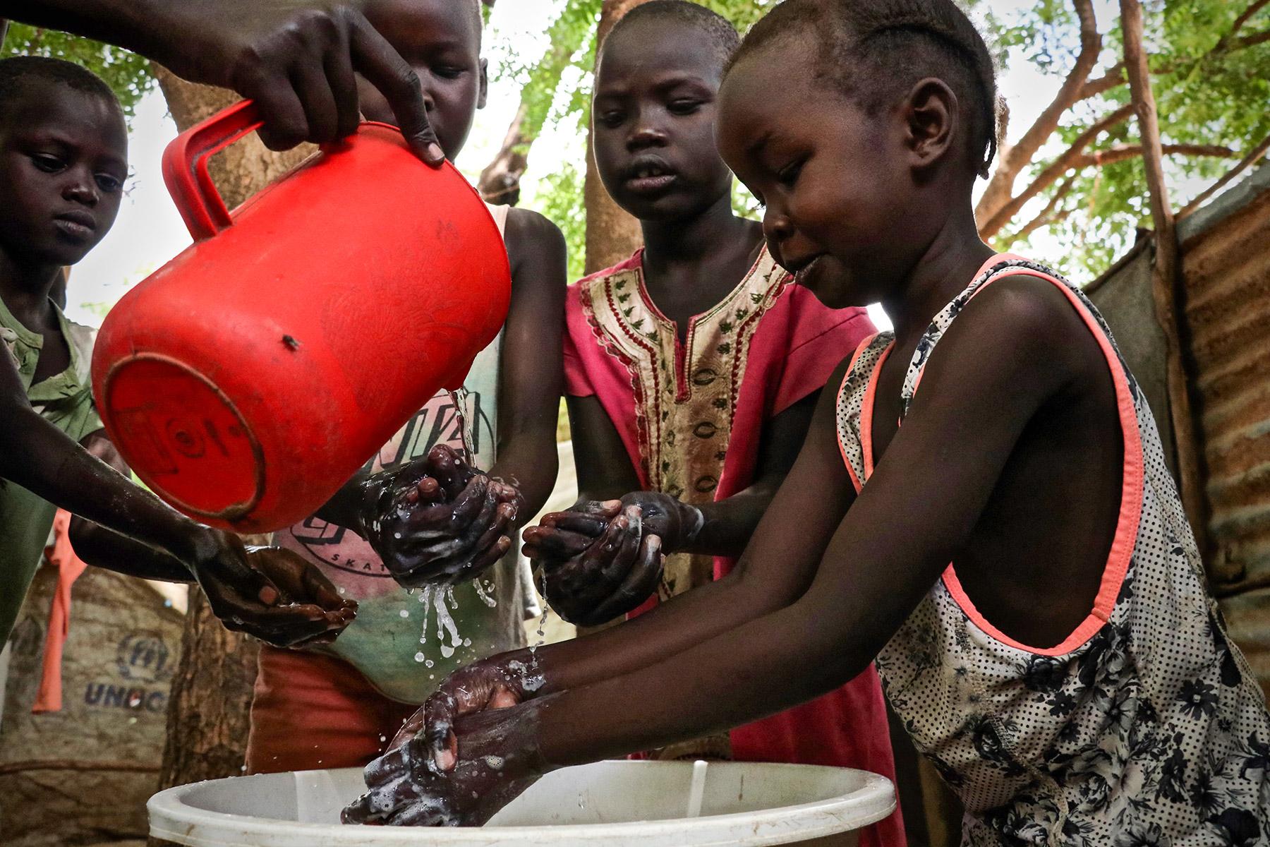 Kinder demonstrieren Händewaschen im Flüchtlingslager Kakuma, Kenia. Der LWB ist der Hauptträger der Bildungsarbeit im Lager, und die Sensibilisierung für Hygiene ist Teil dieser Arbeit. Der LWB hat die Hygieneaufklärung verstärkt, um die Verbreitung von COVID-19 im Lager zu verhindern. Foto: LWB/P. Omagwa