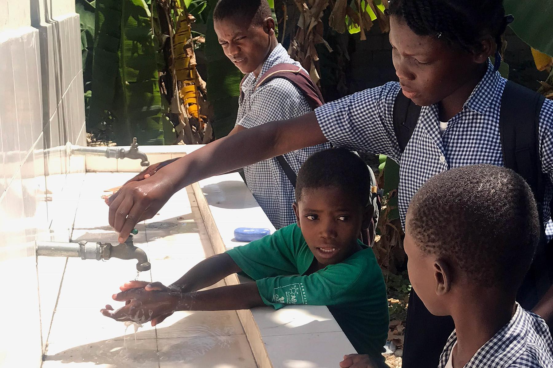 Ältere Schülerinnen und Schüler sind „Botschafterinnen“ und „Botschafter“ des „Hygiene-Clubs“ an der Gressier National School in Haiti. Sie helfen den jüngeren Kindern dabei, zu lernen, wie sie richtig ihre Hände waschen, um sich vor Krankheiten wie COVID-19 zu schützen. Foto: LWB/Starry Sprenkle