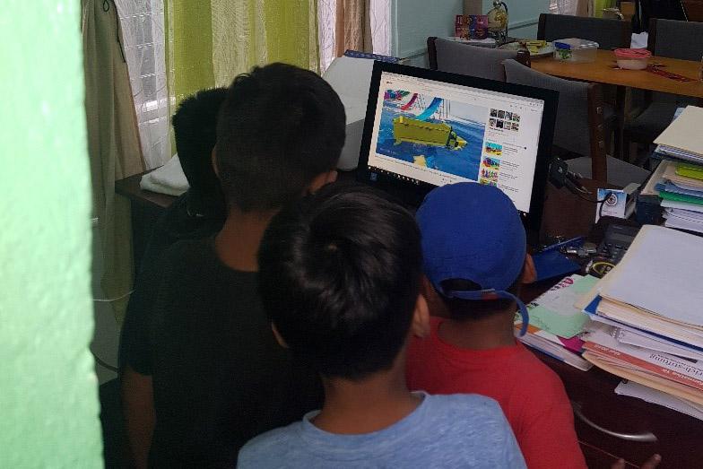 Kinder aus Nicaragua sehen sich im Kirchenbüro ein Video an. Foto: ILCO