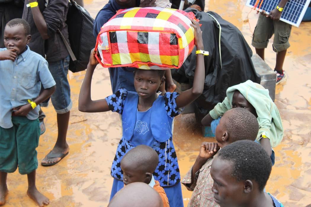 A child arrives arrives at the Elegu collection point on the South Sudan-Uganda border with what she can carry. Photo: LWF/P. Kikomeko 