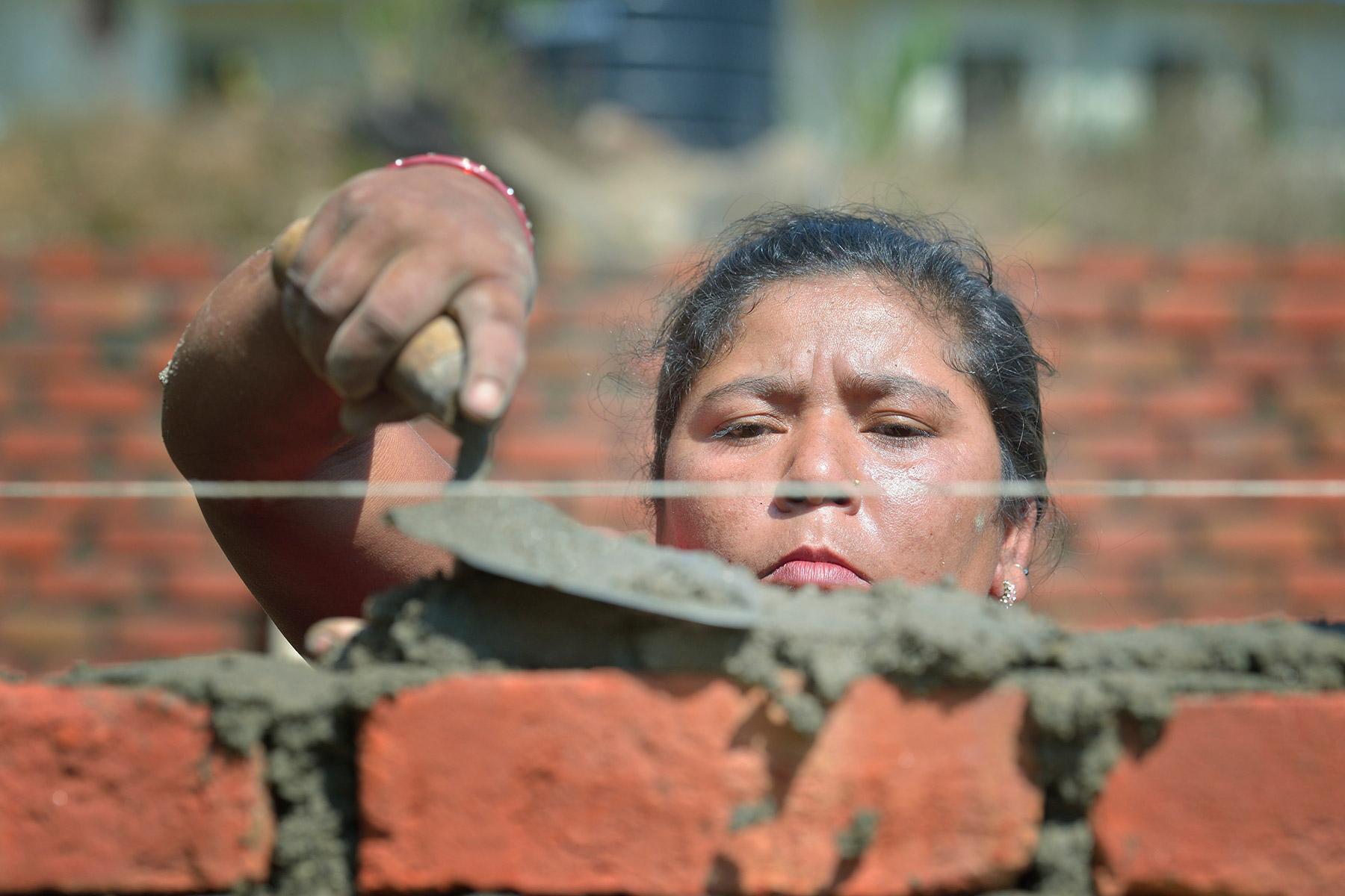 Bhagwati Tamang lays bricks in Jogimara village in central Nepal after the devastating earthquake of April 2015. Following the disaster, the LWF worked jointly with Islamic Relief Worldwide and other partners to provide shelter in remote villages where thousands lost homes and livelihoods. Photo: Paul Jeffrey/ACT
