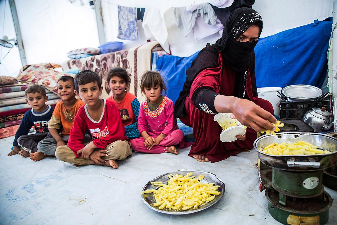 Eine Mutter bereitet ihren Kindern eine Mahlzeit zu. Die Familie floh aus Mossul und lebt nun im Flüchtlingslager Debaga. Fotos: LWB/Seivan Salim