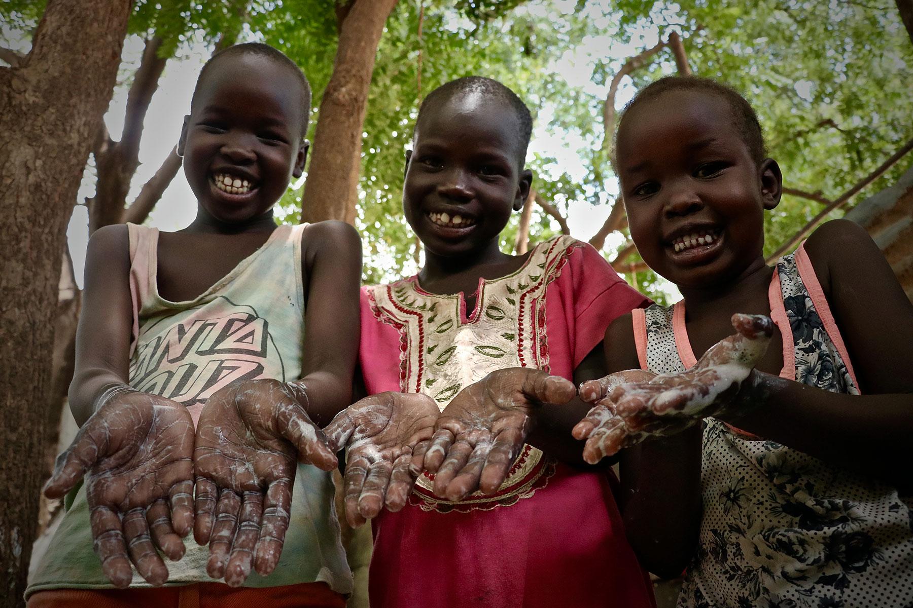 Gründliches Händewaschen mit Seife kann die Verbreitung von COVID-19 verhindern: (v.l.) Freedom Gai (9 Jahre), Nyalat Pouch (7 Jahre) und Nyabena Gai (5 Jahre). Alle Fotos: LWB/A. Kwamboka