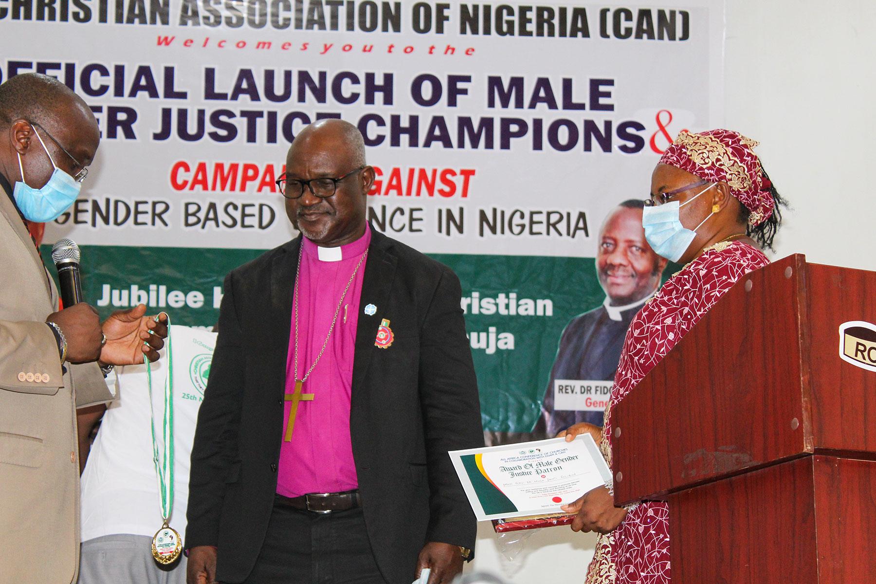 Rev. Dr. Gibson Ezekiel Lesmore (left), AACC director for Peace, Diakonia and Development, presents the Patron of Gender Justice Champion in Africa award to LWF President Archbishop Dr. Panti Filibus Musa. On the right is Ms Rhoda Ezekiel. Photo: ALCINET/Felix Samari