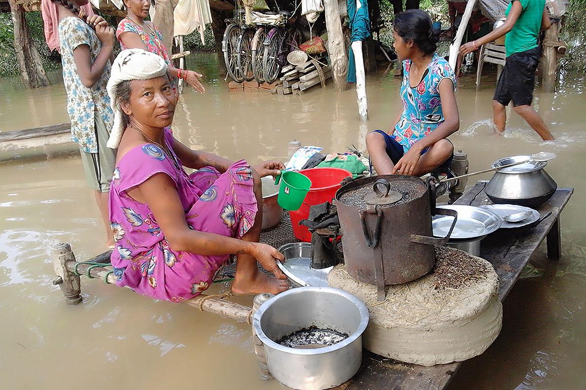 Eine Frau aus der Gemeinde Bhajani, im Bezirk Kailali im äußersten Westen Nepals, bereitet an einer überschwemmten Kochstelle Essen zu. Fotos: LWB/P. Maharjan