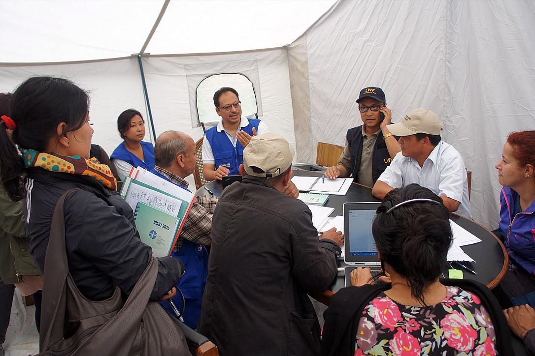 LWF Country Director Nepal, Dr Prabin Manandhar, (center, with blue vest) at a team meeting coordinating the LWF earthquake relief work. Photo: LWF/C. KÃ¤stner 
