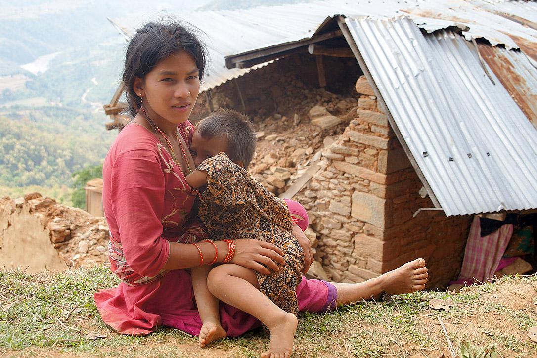 Sapana Roka Sarki stillt ihr jüngstes Kind vor ihrem Haus. Sie hat drei Kinder. Da ihre Lebensgrundlage zerstört ist, sucht ihr Mann im Ausland nach Arbeit. Foto: LWB/ C. Kästner