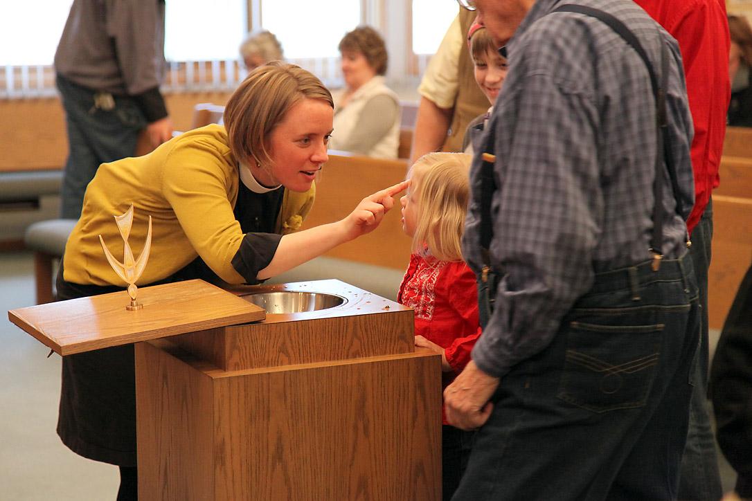 Rev. Taryn Montgomery making the sign of the cross on her daughter's forehead at the Bread of Life Lutheran Church in Minot, North Dakota, United States. Photo: ELCA