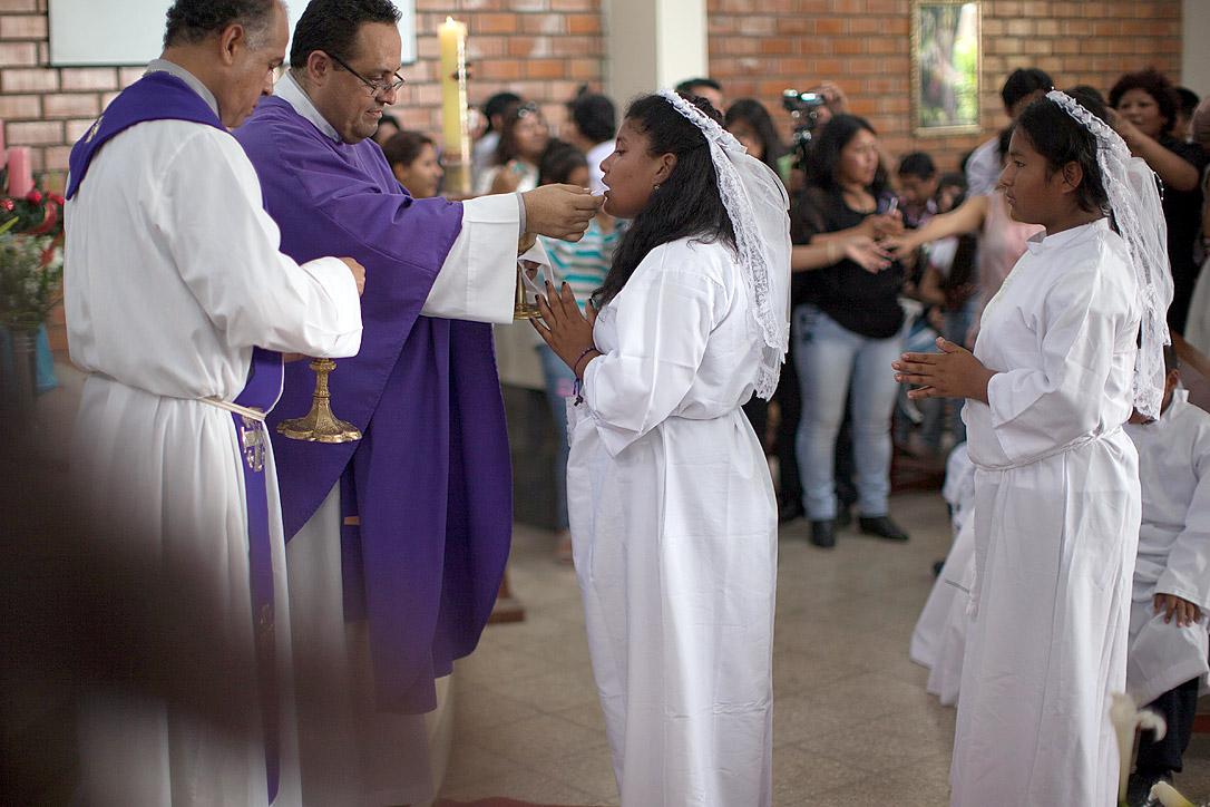 Lutheran pastor Rev.  Pedro BullÃ³n (left) and  Catholic priest Fr. Marco AgÃ¼ero Vidal (right) preside at the joint First Communion in Pamplona Alta, Lima, December 2014. Photo: LWF/Sean Hawkey