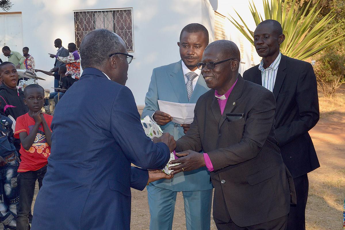 ELCCo Presiding Bishop RenÃ© Mwamba Sumaili offers a gift to Evangelical Lutheran Church in Tanzania General Secretary Brighton Killewa (left). Third from right is ELCCo General Secretary, Gilbert Ilunga Nkasa Talwa. Photo: LWF/Gracia Rubona
