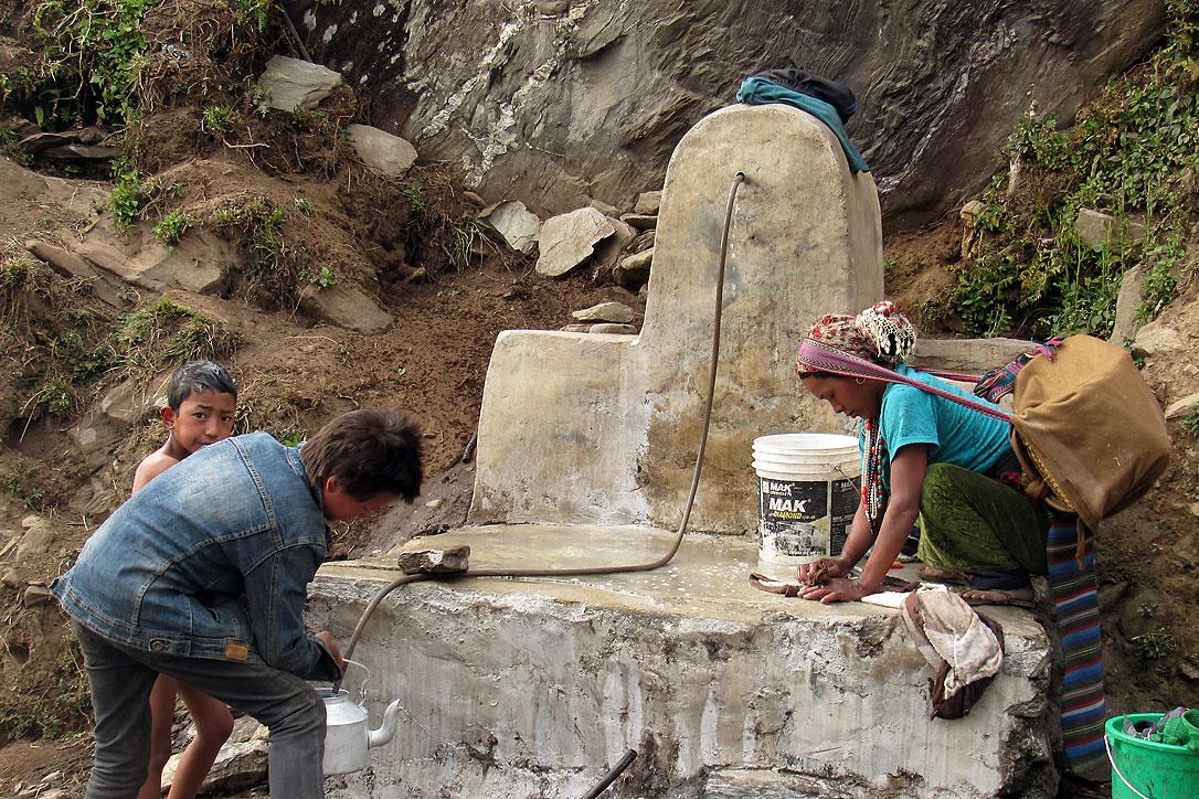Ein Kind stillt seinen Durst an der Wasserstation, die der LWB Nepal und seine lokale Partnerorganisationen HURADEC im zur Gemeinde Jiri zählenden Dorf Pattitar gebaut haben. Foto: LWB/M. Timsina