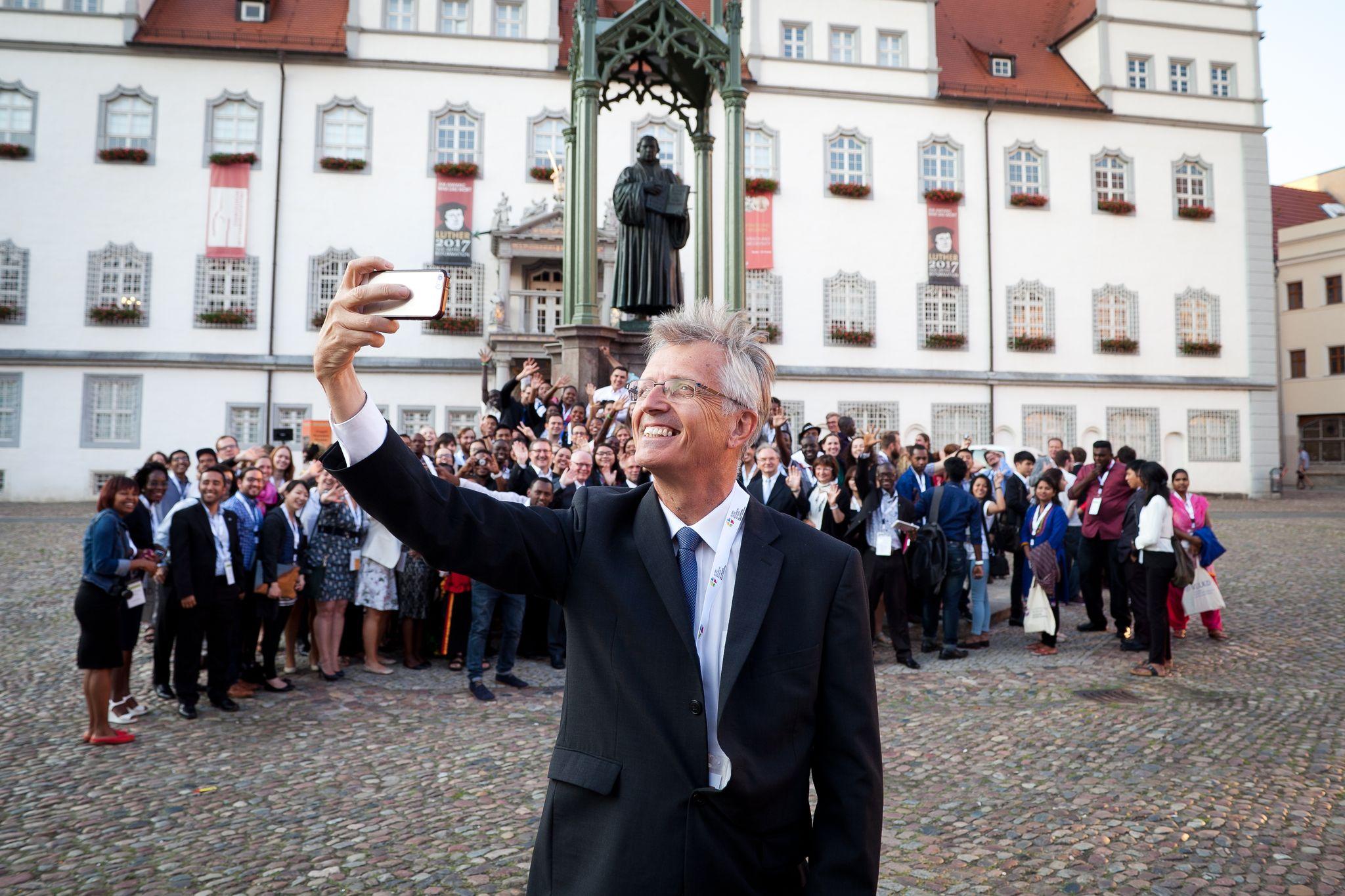LWF General Secretary Martin Junge taking a selfie of himself, the old reformer Martin Luther and the young reformers on a square in Wittenberg. Photo: LWF/Marko Schoeneberg