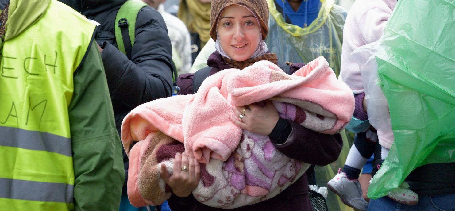 Eine junge Frau nähert sich mit ihrem Baby der kroatischen Grenze bei Berkasovo, Serbien. Hunderrttausende Flüchtlinge, darunter zahlreiche Kinder, durchqueren derzeit Serbien auf ihrem Weg nach Westeuropa. Foto: actalliance/ Paul Jeffrey