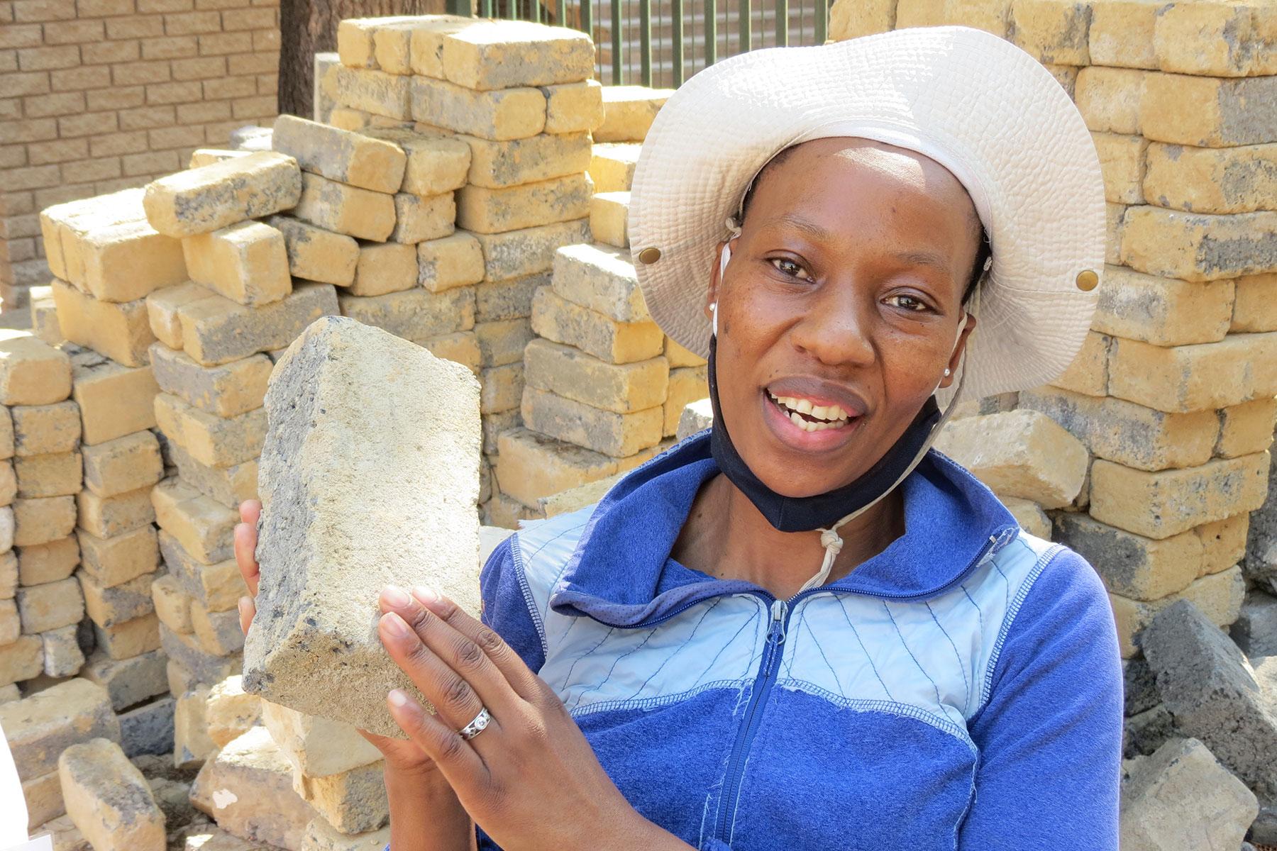 Bricklayer Makhatutu Siimane, showing what she can do with bricks. Photo: Outreach Foundation