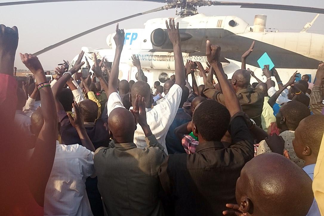 Bei ihrer Rückkehr werden die LWB-Mitarbeitenden am Flughafen Juba von einer Menschenmenge begrüsst. Foto: LWB/E. Mpanya