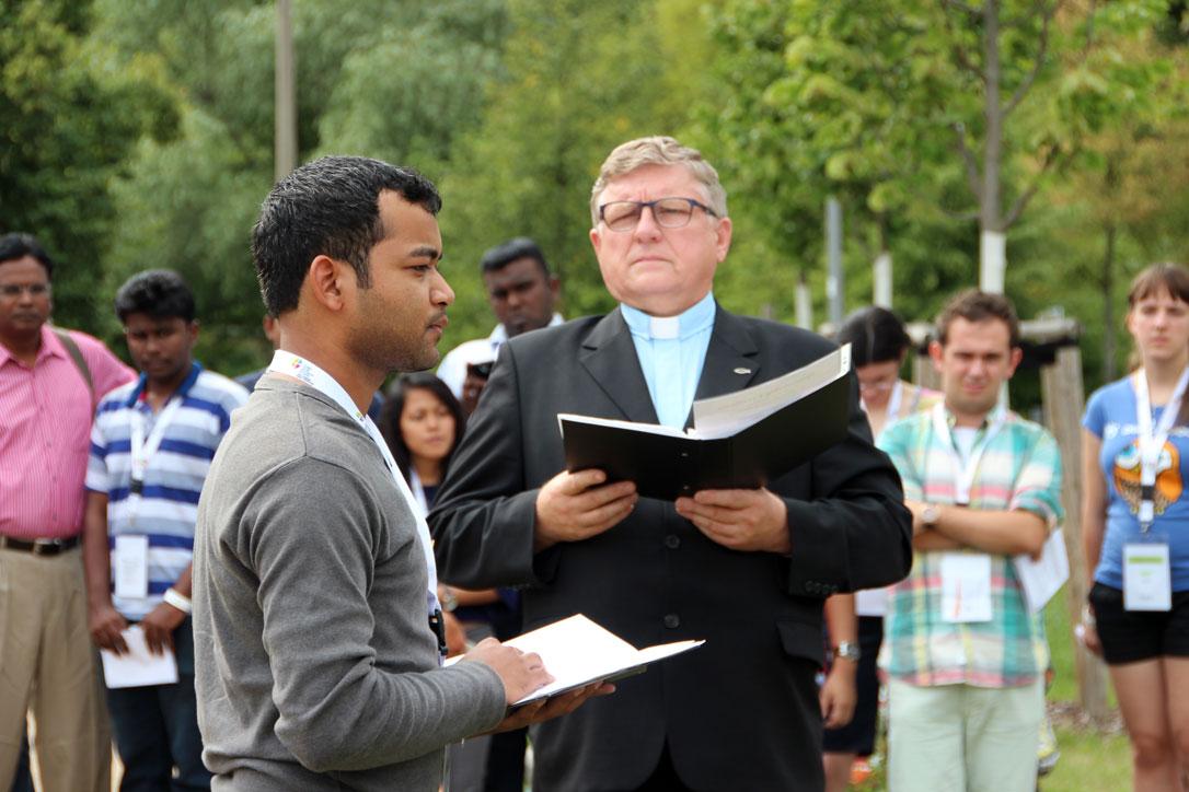 Caption: Benison Kachhap contemplates the significance of being the first young Lutheran to plant a tree in the renowned Luther Garden, in Wittenberg. Rev. Hans Kasch, director of the LWF Center in Wittenberg, looks on. Photo: GNC/LWF/F. HÃ¼bner 