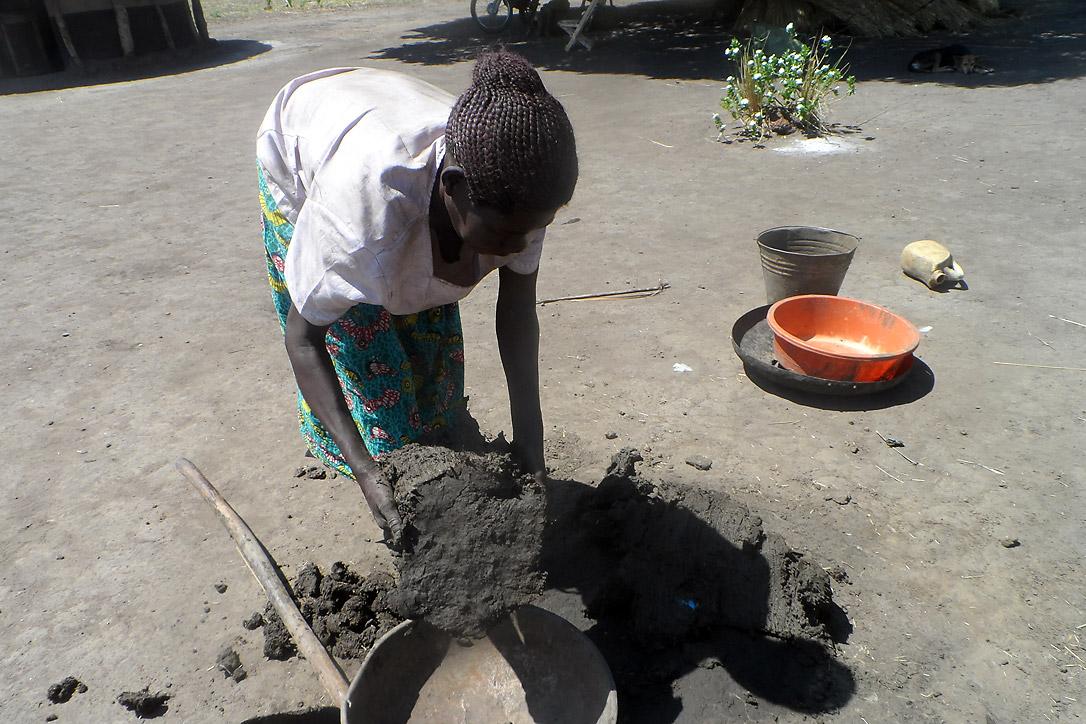 Margret Akot bereitet Lehm für den Bau von Kochherden vor. Foto: LWB-Uganda