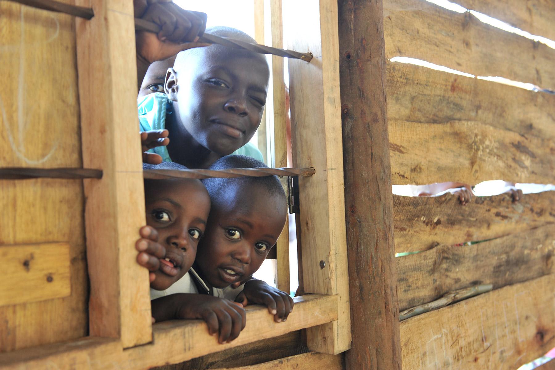 Children looking by a window at the Katalyeba Early Learning Center, in Rwamwanja, Uganda. The center welcomes children from both the host community and the refugee settlement. Photo credit: LWF/M. Renaux