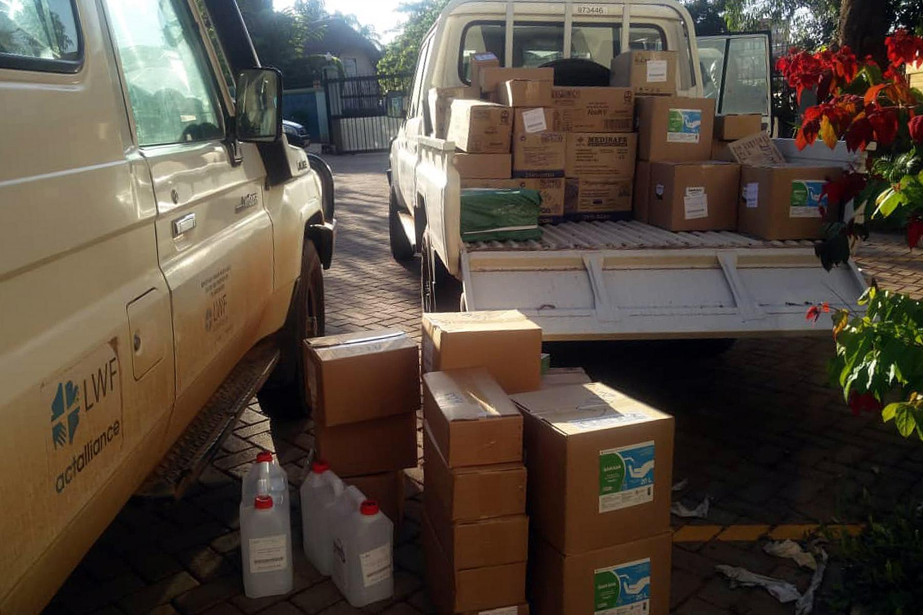 Persönliche Schutzausrüstungen und Hygieneartikel werden auf einen Pickup geladen, der sie zum LWB- Personal in den Flüchtlingssiedlungen in Uganda transportiert. Fotos: Hope Opio/LWB Uganda