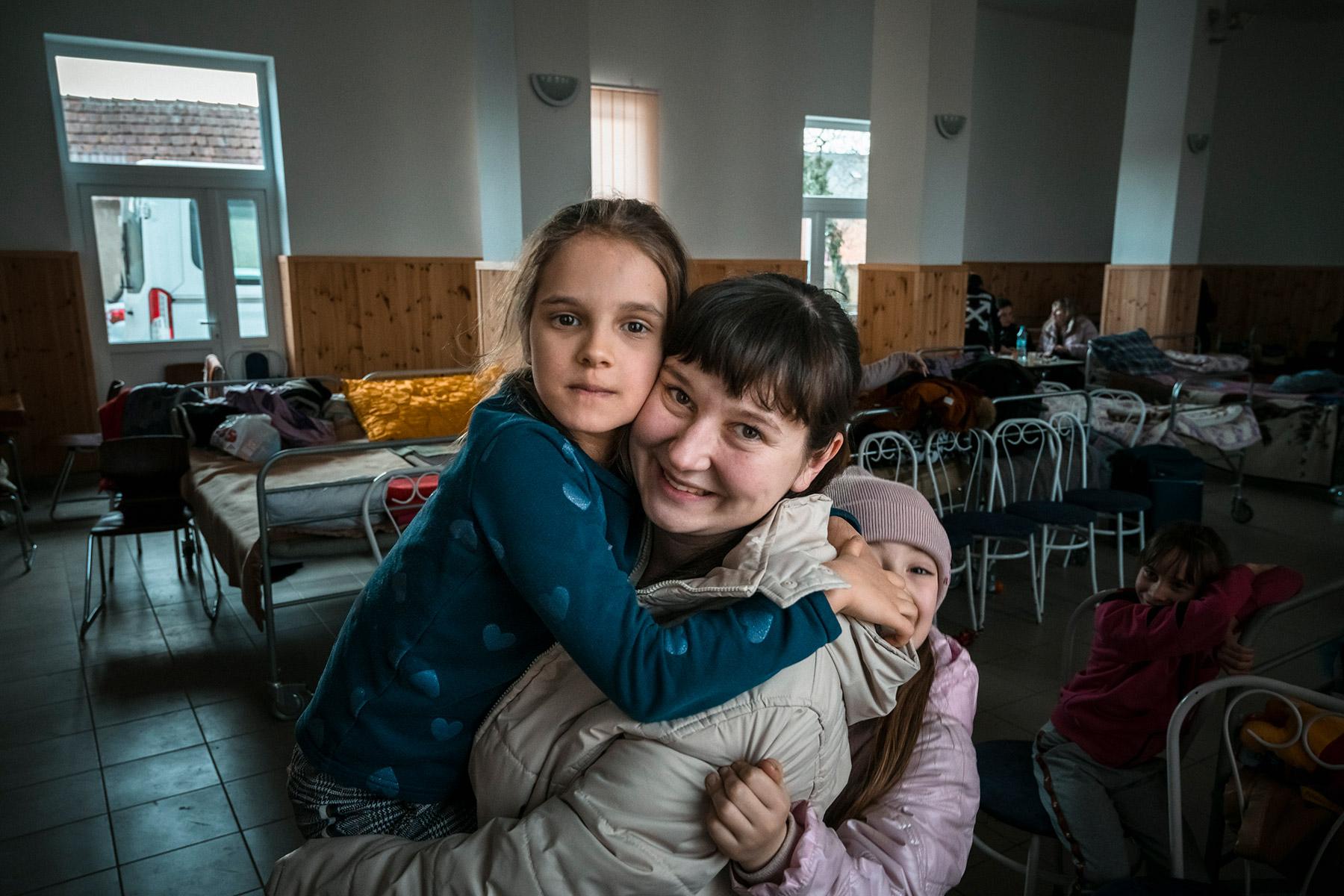 A Ukrainian refugee, Masha, with two of her children, at an aid station at the Ukrainian-Hungarian border on 2 March 2022. Masha, her husband and nine children fled from near the Crimean Peninsula and are receiving aid at a shelter where ACT Alliance member Hungarian Interchurch Aid is assisting Ukrainian refugees. Photo: FCA/Antti YrjÃ¶nen