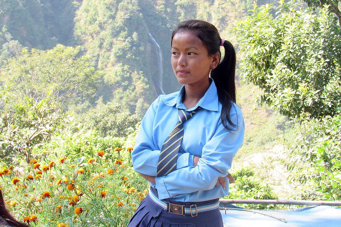Sanu in ihrer Schuluniform. Die Aussicht auf eine höhere Schulbildung hat sie dazu veranlasst, nach Möglichkeiten für den Besuch einer Schule zu suchen, die einen Tagesmarsch von ihrem Haus entfernt ist. Foto: Umesh Pokharel/LWB Nepal