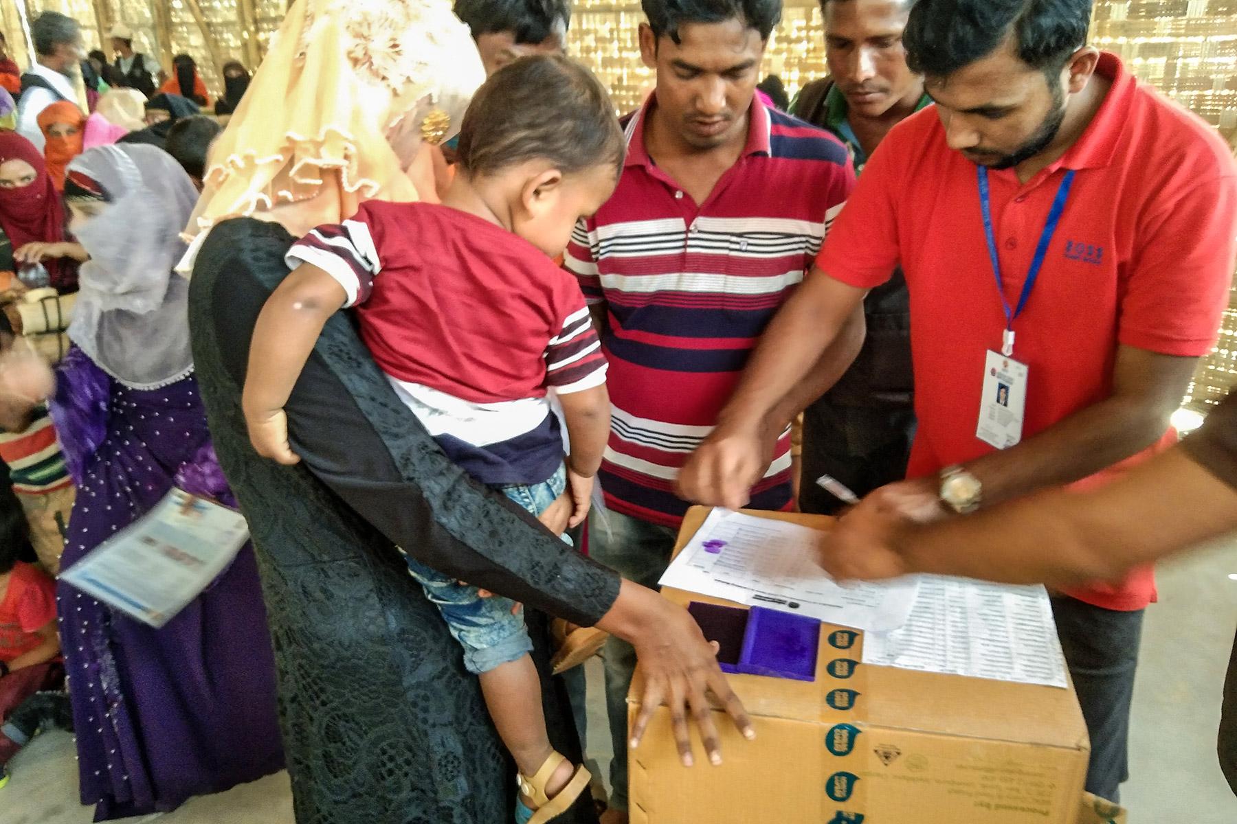 A refugee mother offers her finger print to receive supplementary food items in the refugee camp #18 in Coxâs Bazaar, Bangladesh. Photo: LWF Nepal/Bhoj Raj Khanal