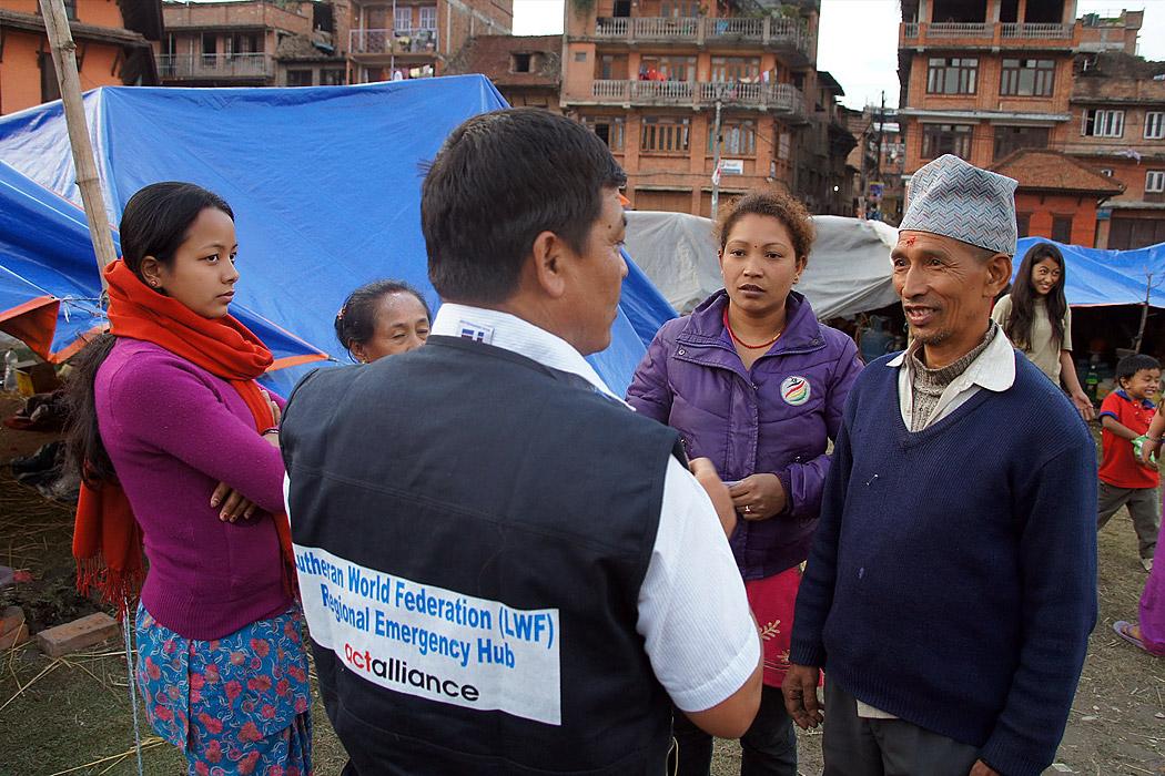 LWF staff member Yadu Lal Shresta (centre), of the LWF Asia emergency hub team, talks to survivors about their living conditions in a camp in Bhaktapur, the worst-affected district of Kathmandu valley. Photo: LWF/C. KÃ¤stner