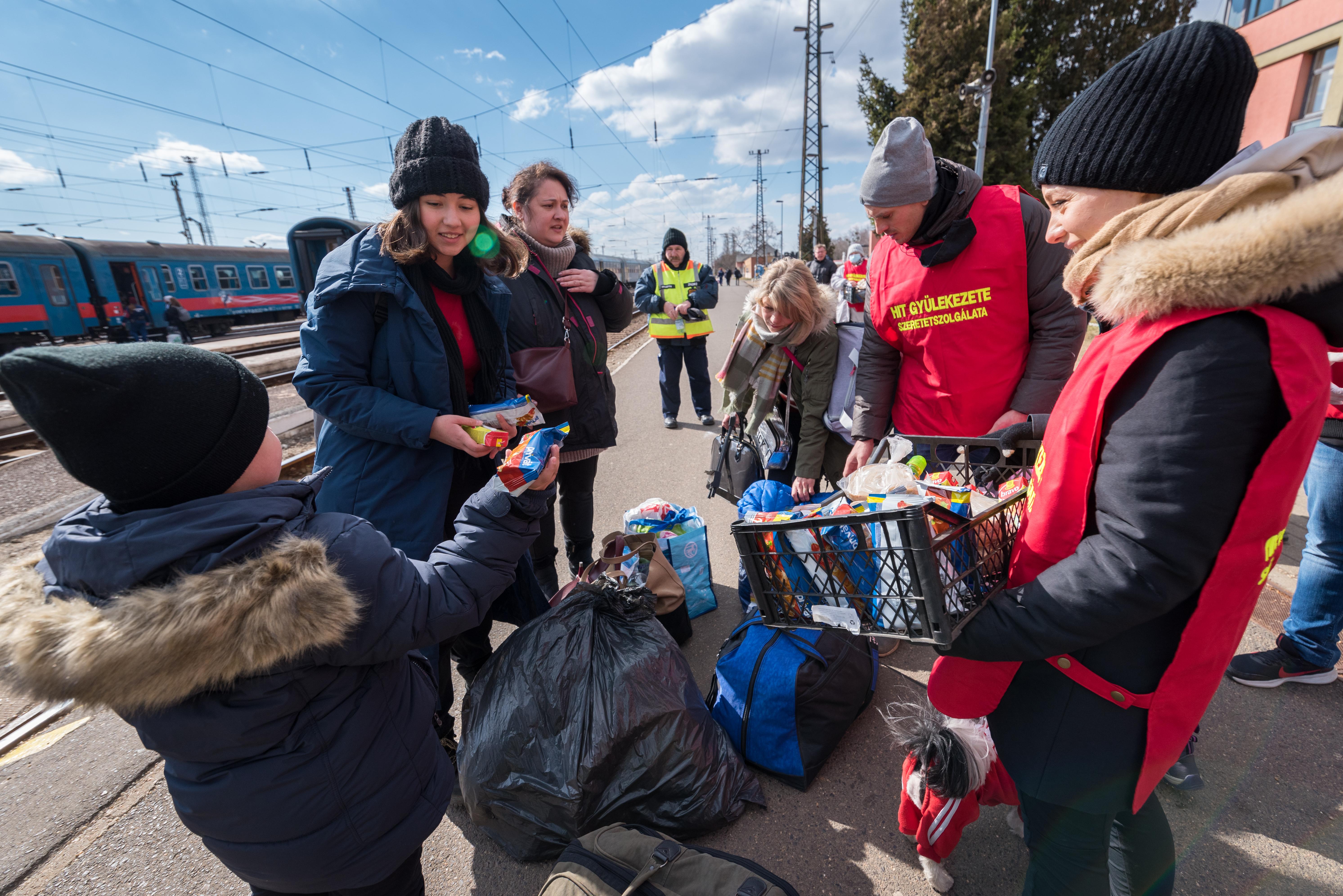 Ukrainische Flüchtlingsfamilien werden bei ihrer Ankunft am Bahnhof in Záhony, Ungarn, von Helfenden unterstützt. Foto: LWB/Albin Hillert