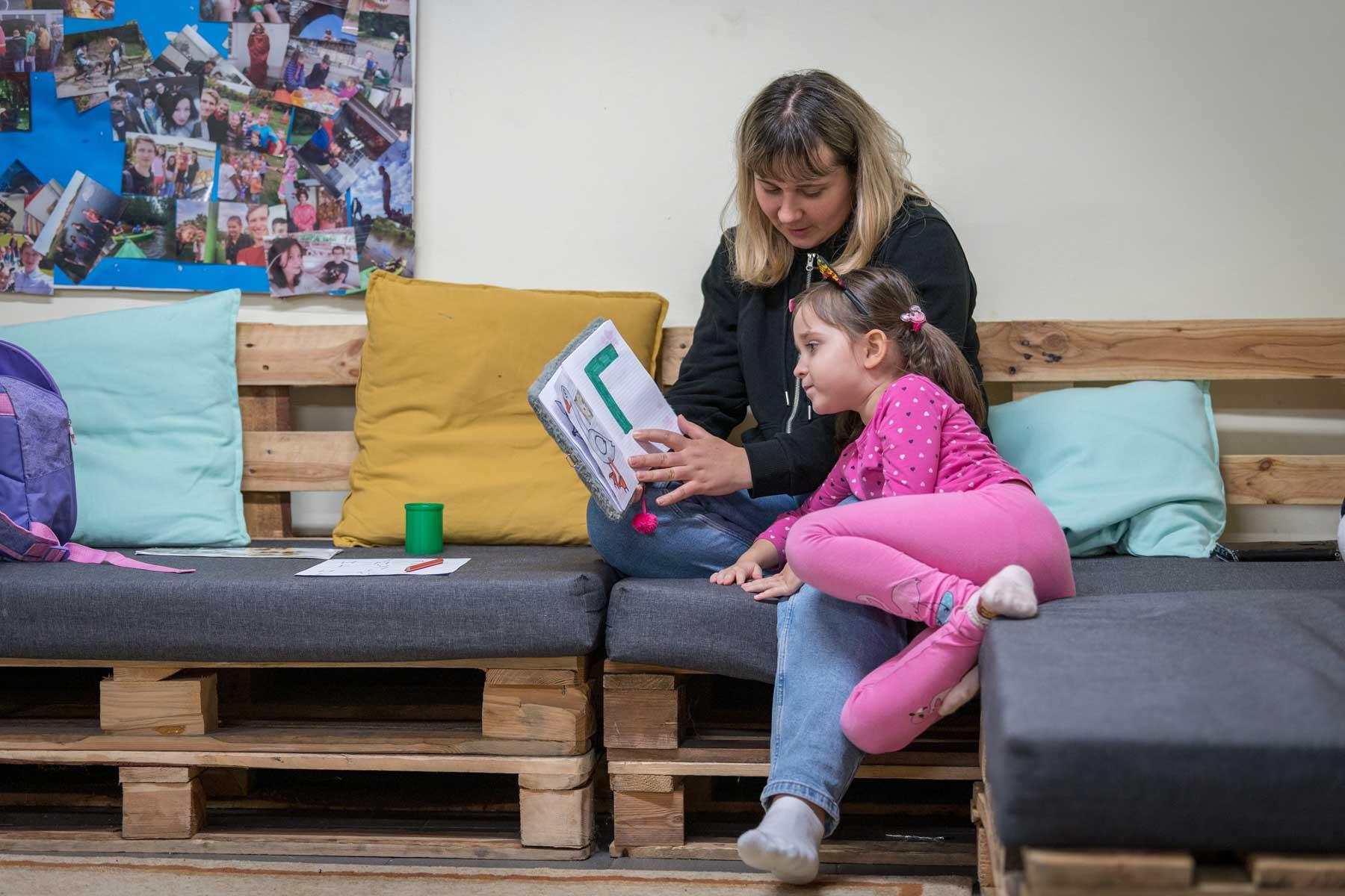 Katiia Kharytoniuk (37) and her daughter Sofija (5) practice the alphabet together. Katiia arrived as a refugee in Poland from Uman, Ukraine, together with her two daughters. After three months staying in the home of a Polish family, she now lives with her daughters in a building at the Evangelical Church of the Augsburg Confession in Poland parish in Bytom. The father of the family remains in Ukraine, as men aged 18-60 are not allowed to leave the country. Photo: LWF/Albin Hillert