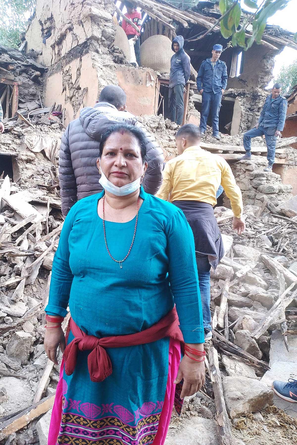 Eine Frau steht vor ihrem eingestürzten Haus. Foto: Bhakta Raj Upadhyay/IP-USSBM Doti