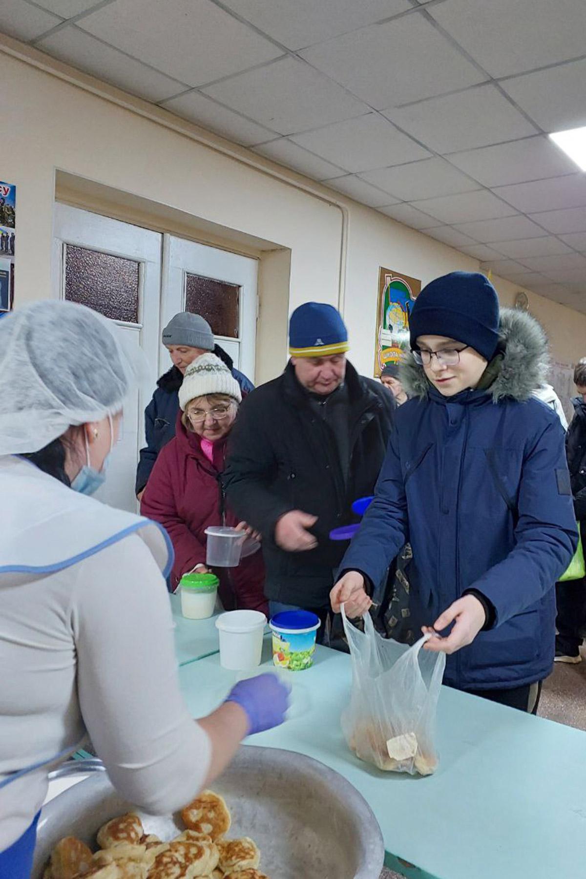 Menschen aus Charkiw bekommen in einem Wärmepunkt Lebensmittelhilfen. Foto: Ekocity/Jugendrat Charkiw